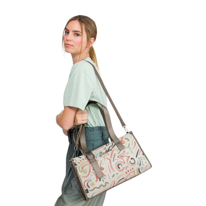 Model wearing a beige Anekke casual handbag with colorful abstract patterns, featuring dual handles and a shoulder strap.