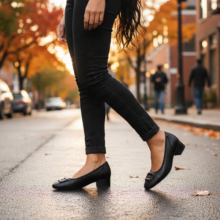 ada-shoes.ro Rieker black leather ballet flats with a small block heel and decorative buckle worn on a city street