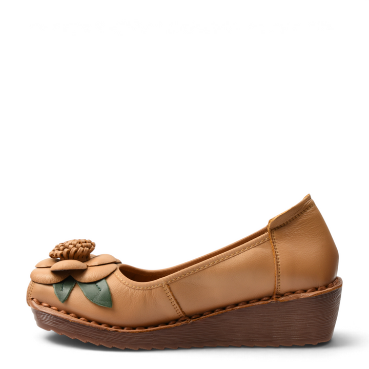 ada-shoes.ro Formazione camel leather wedge shoes with a 3D floral accent and green leaves on a white background
