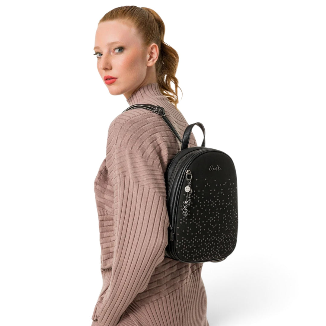 ada-shoes.ro Anekke black casual backpack with metallic stud details and heart charms worn by a model
