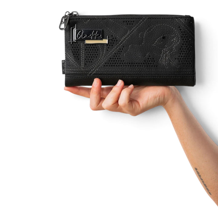ada-shoes.ro Anekke Iron black PU wallet with RFID protection, laser-cut details, and metal logo held in a hand.