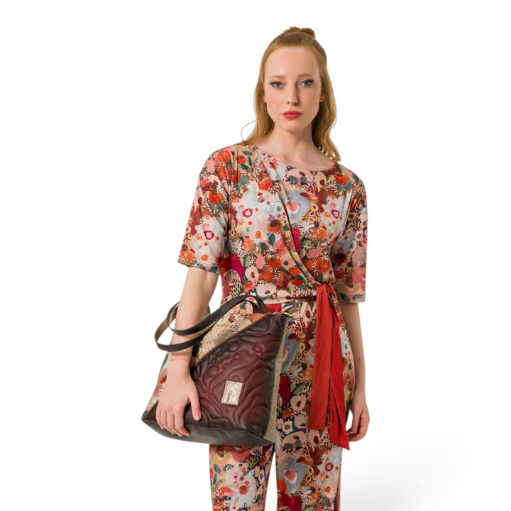 Model holding an elegant Anekke Blossom shoulder bag with floral prints and brown quilted details from ada-shoes.ro