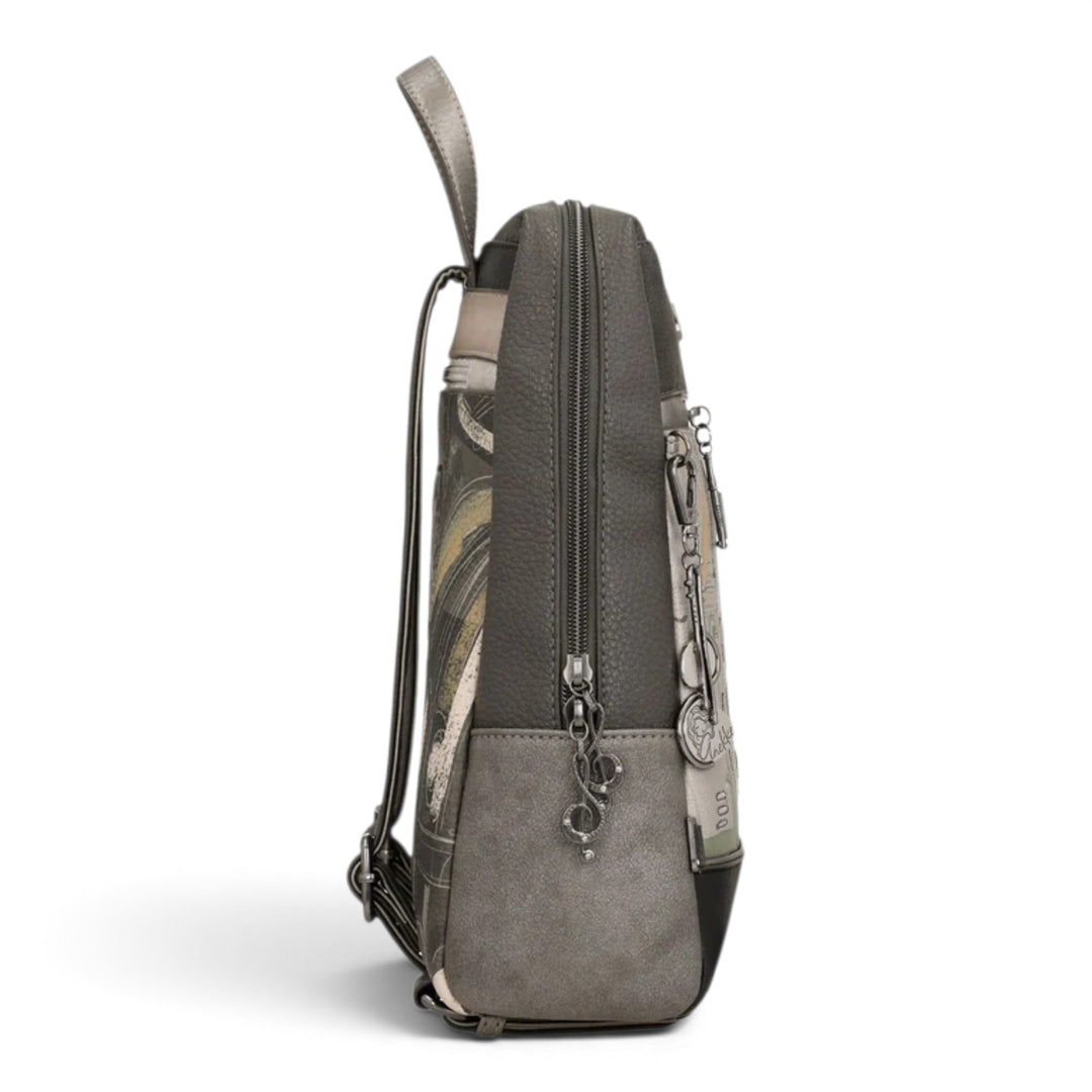 Side view of an Anekke casual backpack in grey and taupe tones with artistic prints, metal charms, and zip closure.