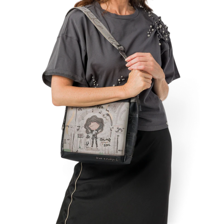 ada-shoes.ro Anekke crossbody bag with artistic illustration, adjustable strap, and three compartments on a model.