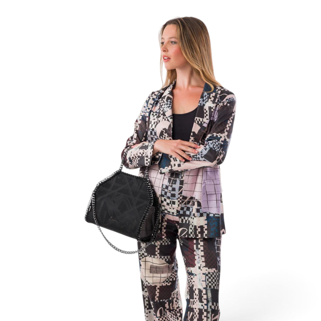 ada-shoes.ro Anekke Iron shoulder bag in black with metallic chain detail, held by a woman in a patterned suit