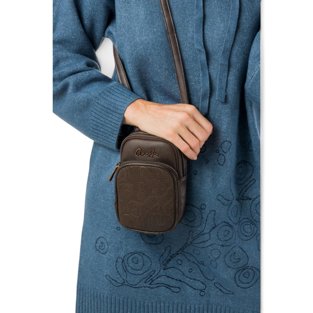 ada-shoes.ro Anekke mocha brown crossbody bag with embossed pattern and adjustable strap worn by a woman
