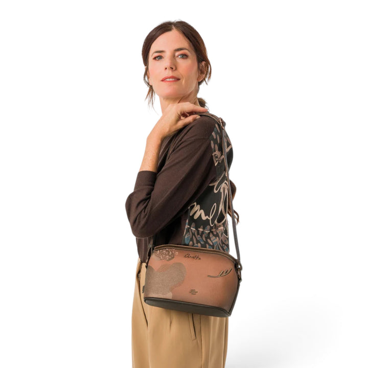 ada-shoes.ro Anekke Voyage crossbody bag with three compartments, worn by a woman in a brown sweater and beige trousers.