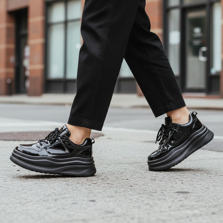 ada-shoes.ro black patent leather platform sneakers with lace-up closure worn on city street