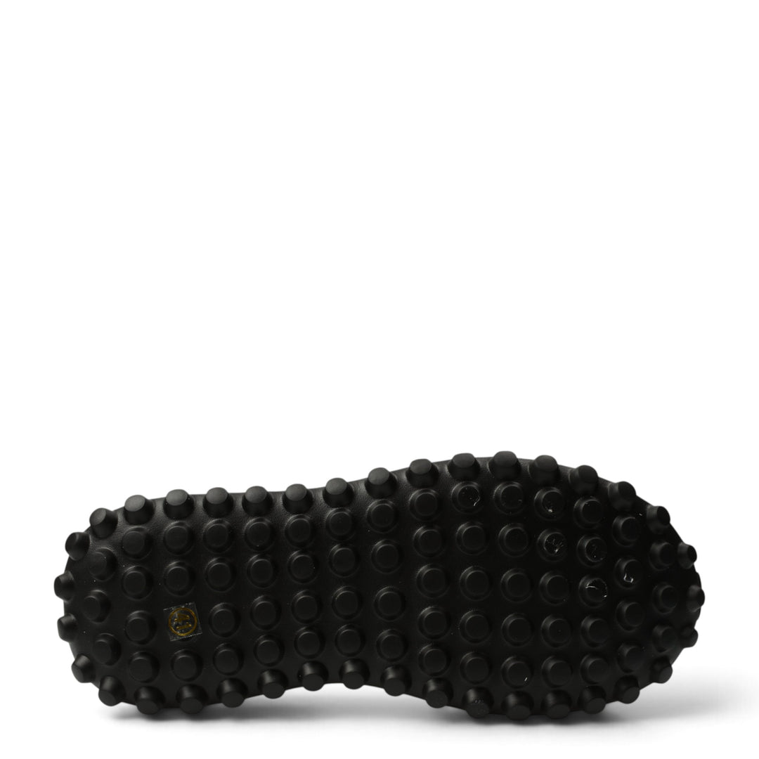 Black rubber outsole of ada-shoes.ro 7077 sneakers featuring a textured grip pattern for stability