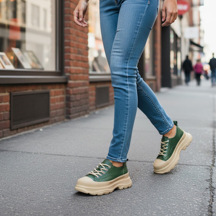 ada-shoes.ro green leather sneakers with chunky beige platform soles worn with blue jeans on a city sidewalk