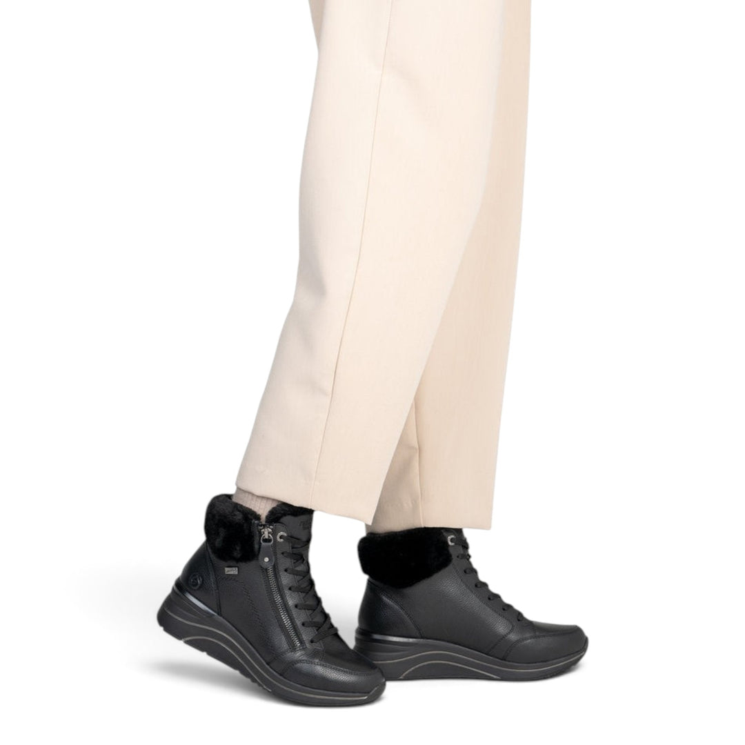 ada-shoes.ro Remonte black leather ankle boots with wool lining, side zippers, and laces, worn with beige trousers.