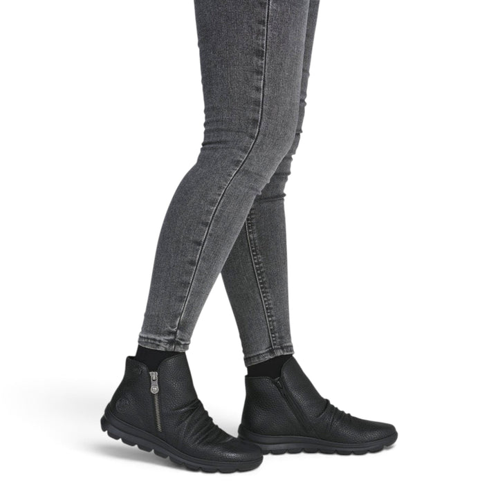 ada-shoes.ro Rieker black leather casual ankle boots with side zipper and flexible sole worn by a woman