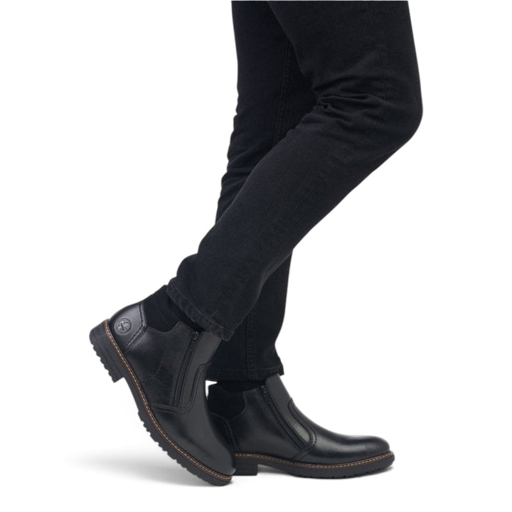 ada-shoes.ro Rieker black leather ankle boots with side zipper and wool lining worn by a man in casual trousers