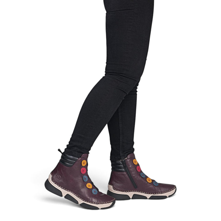 ada-shoes.ro Rieker burgundy faux leather ankle boots with side zipper and colorful decorative buttons on a model