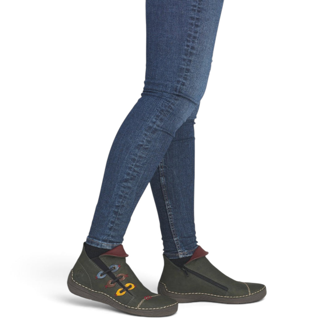 ada-shoes.ro Rieker green faux leather ankle boots with side zipper and colorful decorative stitching on a model