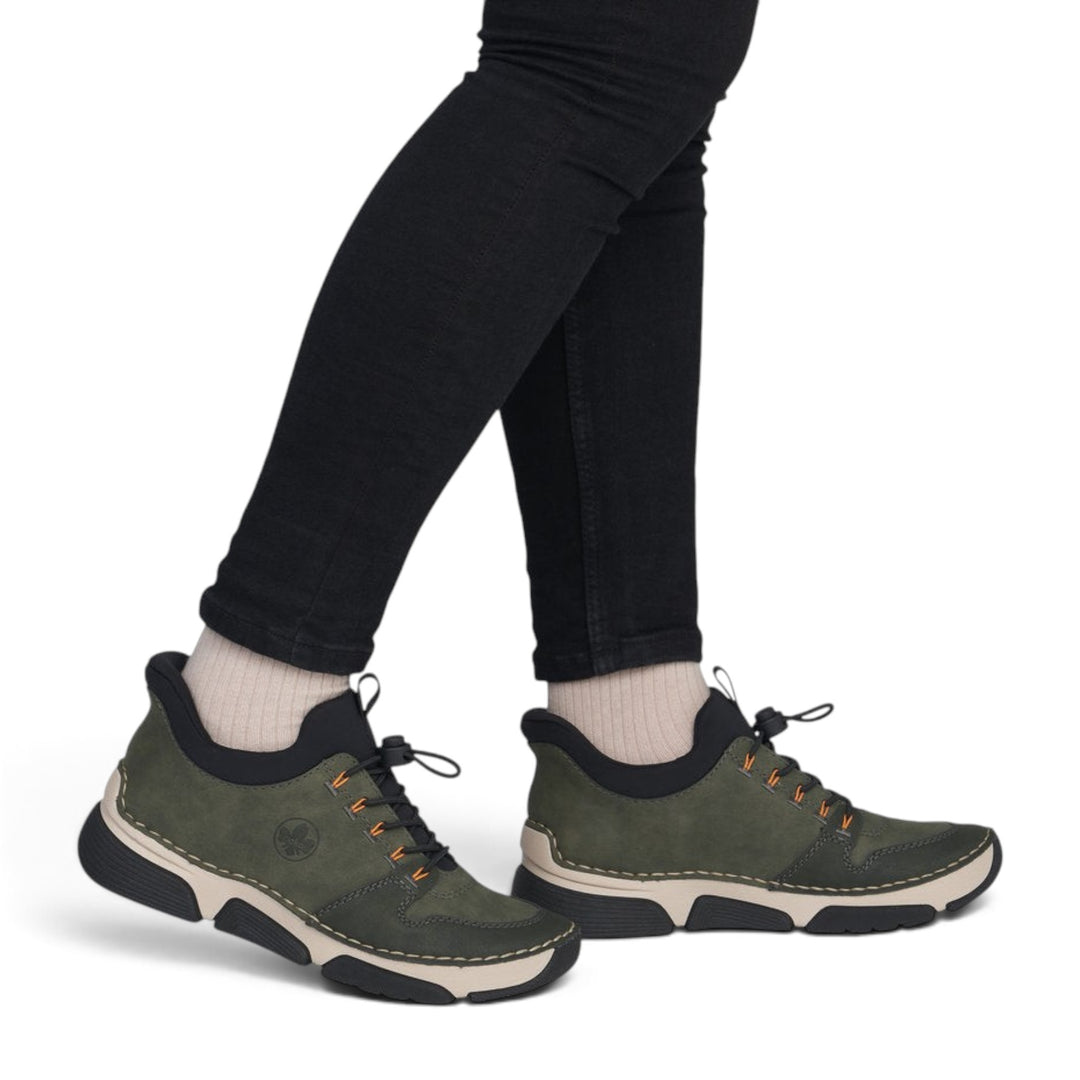 ada-shoes.ro RIEKER khaki green casual sneakers with orange accents, elastic laces, and flexible grip sole on model