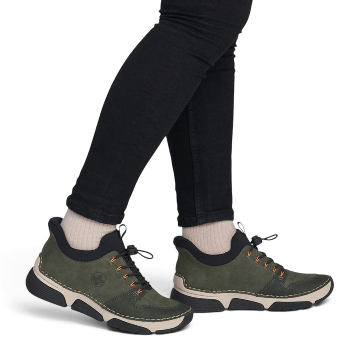 ada-shoes.ro RIEKER khaki green casual sneakers with orange accents, elastic laces, and flexible grip sole on model