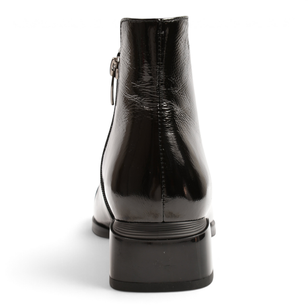 Back view of black patent leather Epica ankle boots with a low block heel and side zipper closure.