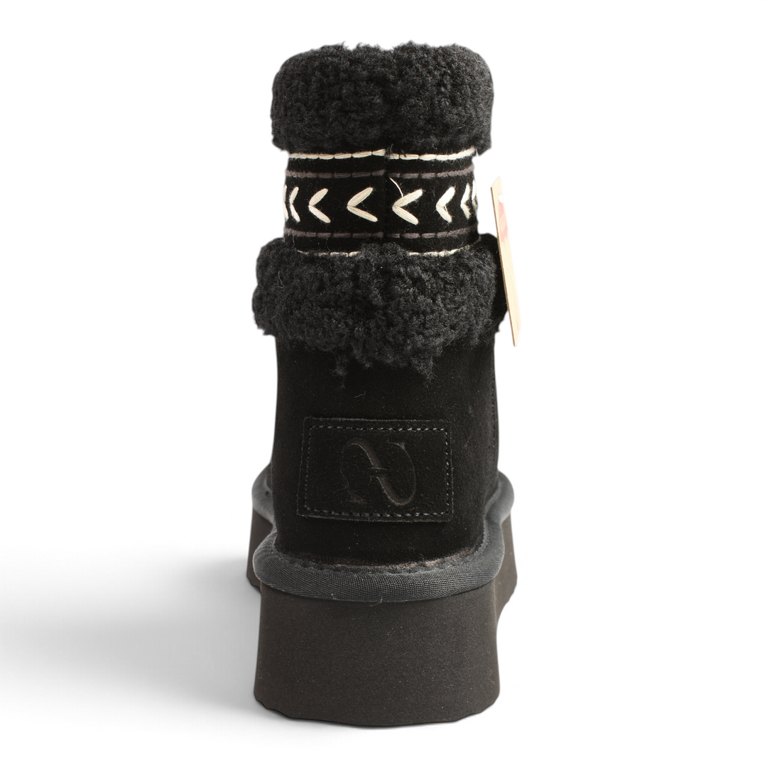 Back view of black Anna Viotti suede winter boots with faux fur collar, platform sole, and white ethnic embroidery.