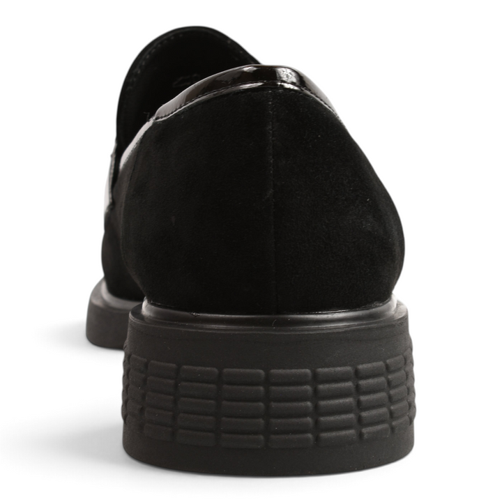 Back view of black suede Anna Viotti loafers with a textured low heel and glossy patent leather trim.