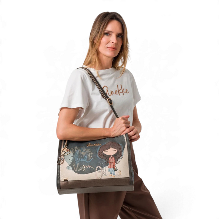Model wearing an Anekke Bloom shopper bag in beige and brown faux leather with artistic print and gold accents