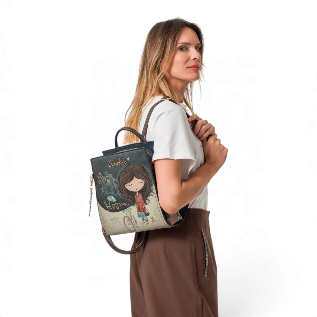 Woman wearing an artistic Anekke Bloom collection backpack in beige and blue faux leather with detailed illustrations.